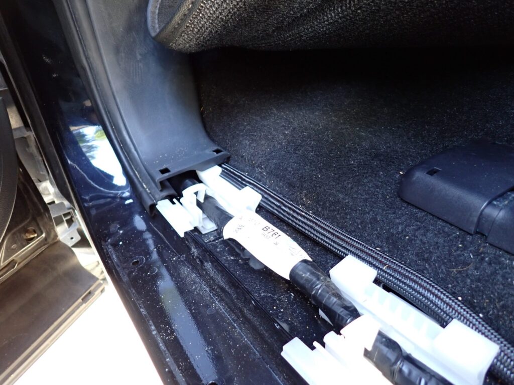 車内の内装に沿わせてケーブルを這わせている様子の写真