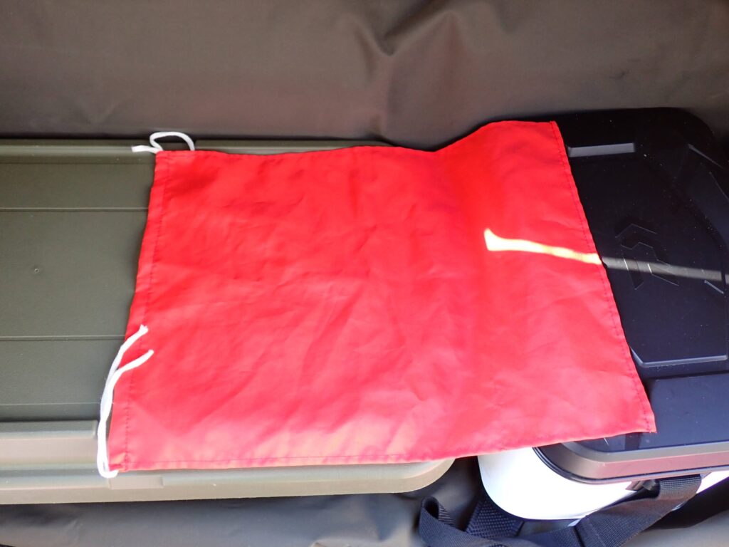 SUPに取り付けた赤いフラッグの写真。船や他の釣り人から位置を知らせるための高視認性の安全装備を示すイメージ。