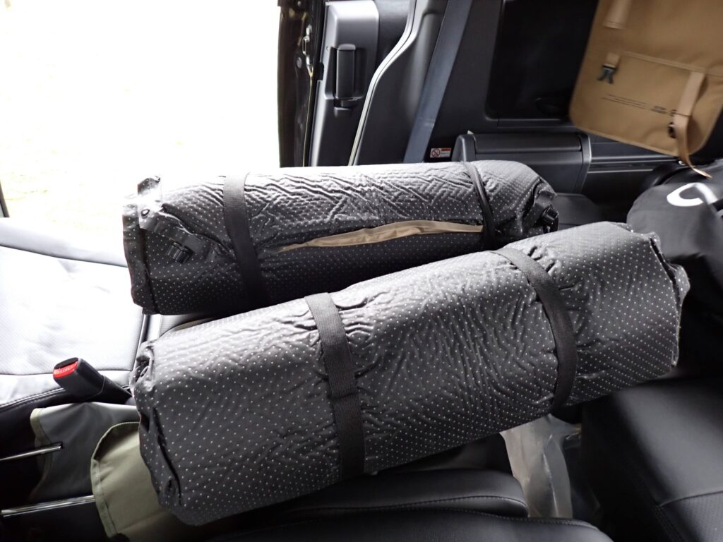 QUICK CAMPインフレータブルマットを丸めて撤収作業をしている様子