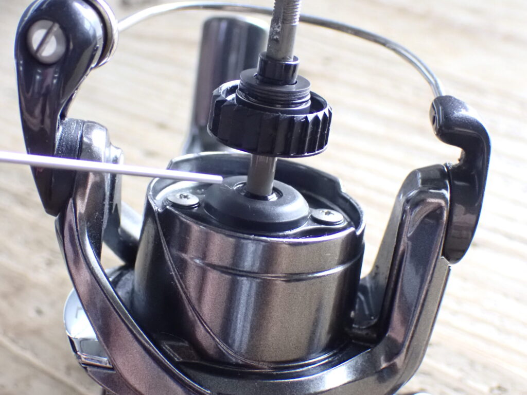 リールのシャフトにオイルをスプレーしている様子