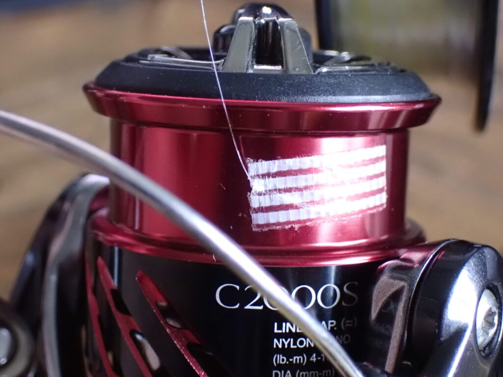 リールスプールにテープでラインを固定している様子